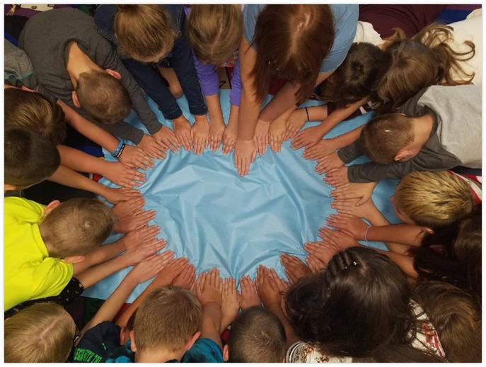 HBE students form a heart shape by placing their hands in the middle of the ring.